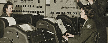 Vintage photo of women operators working at early aviation communication consoles, illustrating the historical evolution of NOTAM systems.