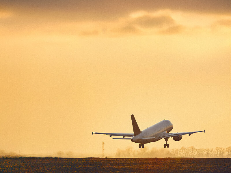 Commercial aircraft lifting off at sunset, symbolizing fuel-efficient departures and arrivals through optimized SIDs and STARs.