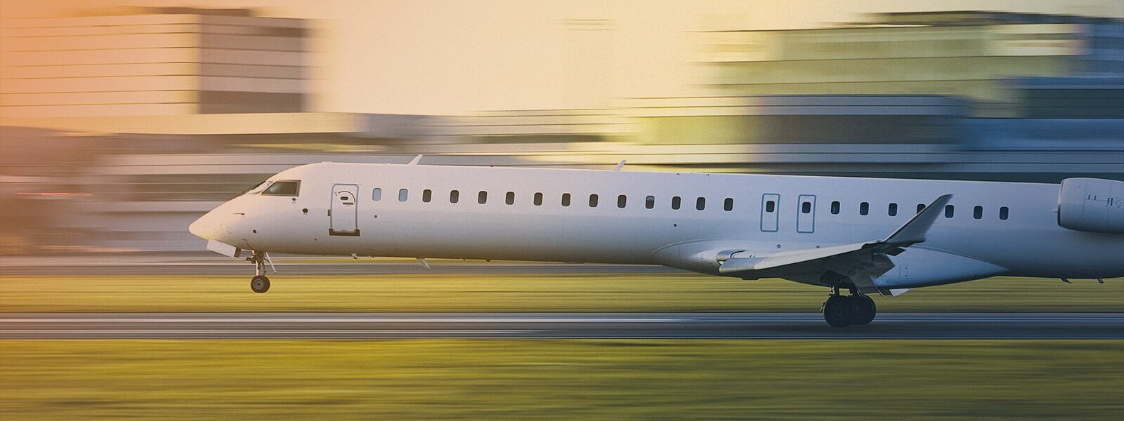 Airplane going on a runway with the sun setting in the background, showcasing flight safety technology in action.