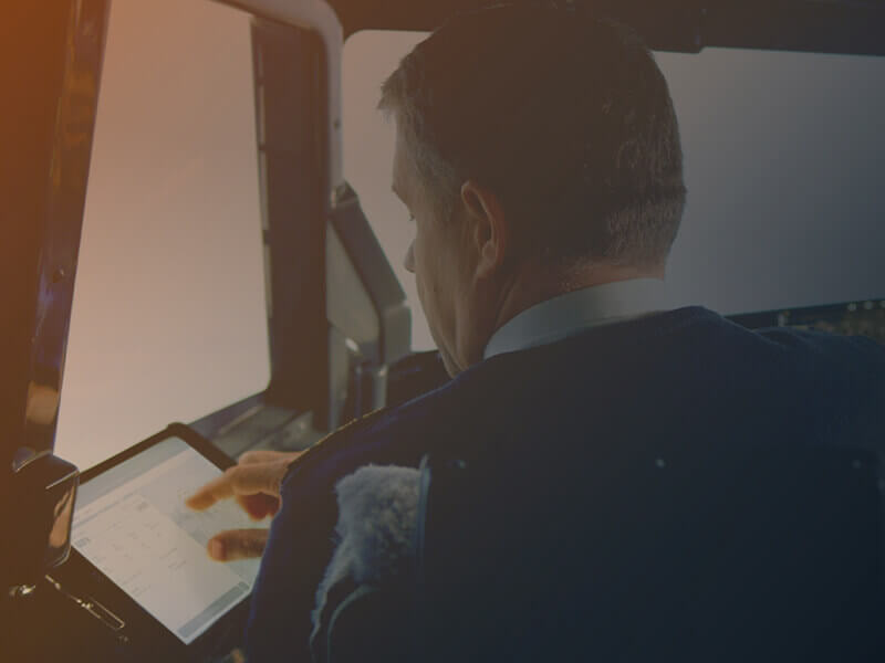 Pilot using a tablet with AIR SUPPORT’s CrewBriefing App, highlighting the benefits of a modern, paperless cockpit environment.