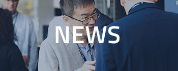 Banner with text “NEWS” over background of professionals conversing at a business networking event.